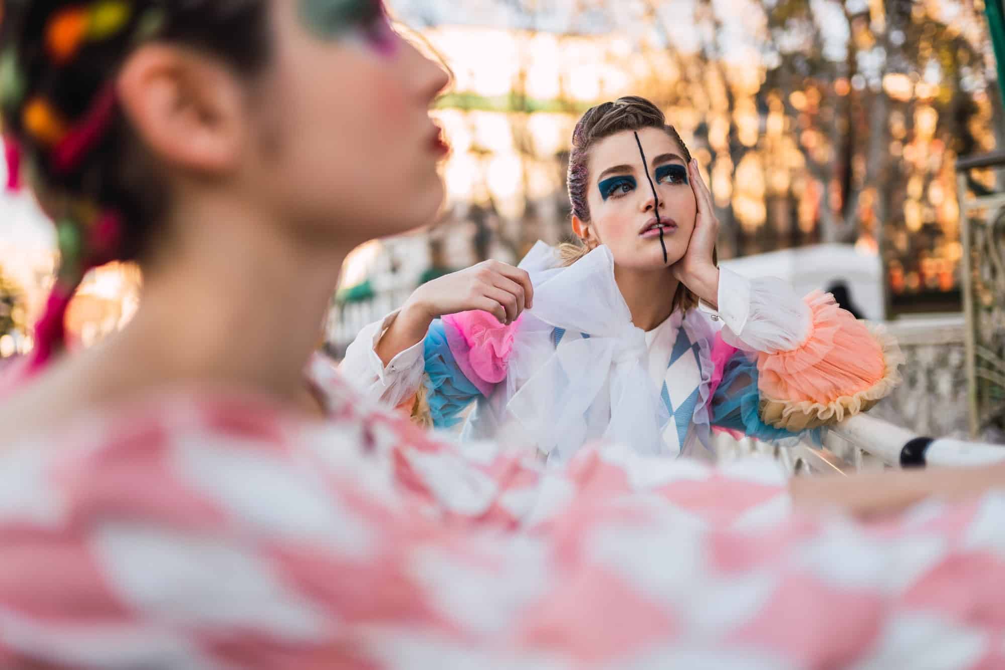 Sensual street artist standing near fence