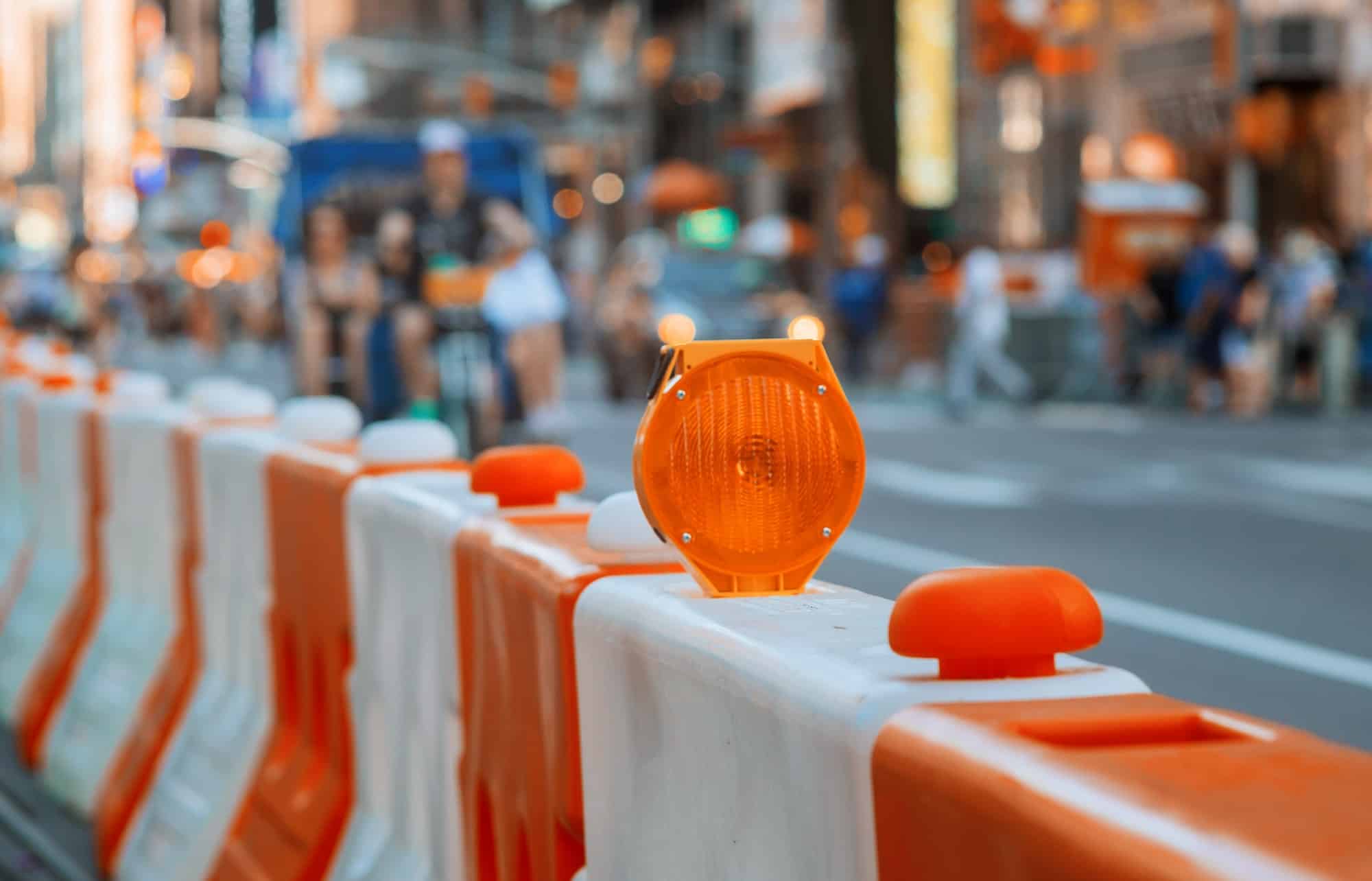 Roadblock or construction with signal on a road red and white street barricade.