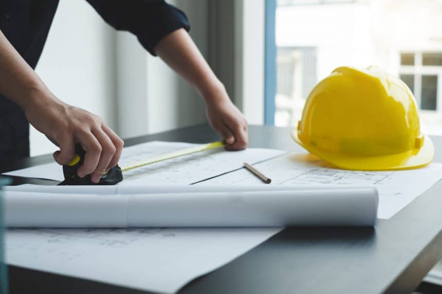 Architects or engineers working construction and drawing construction plans, printing