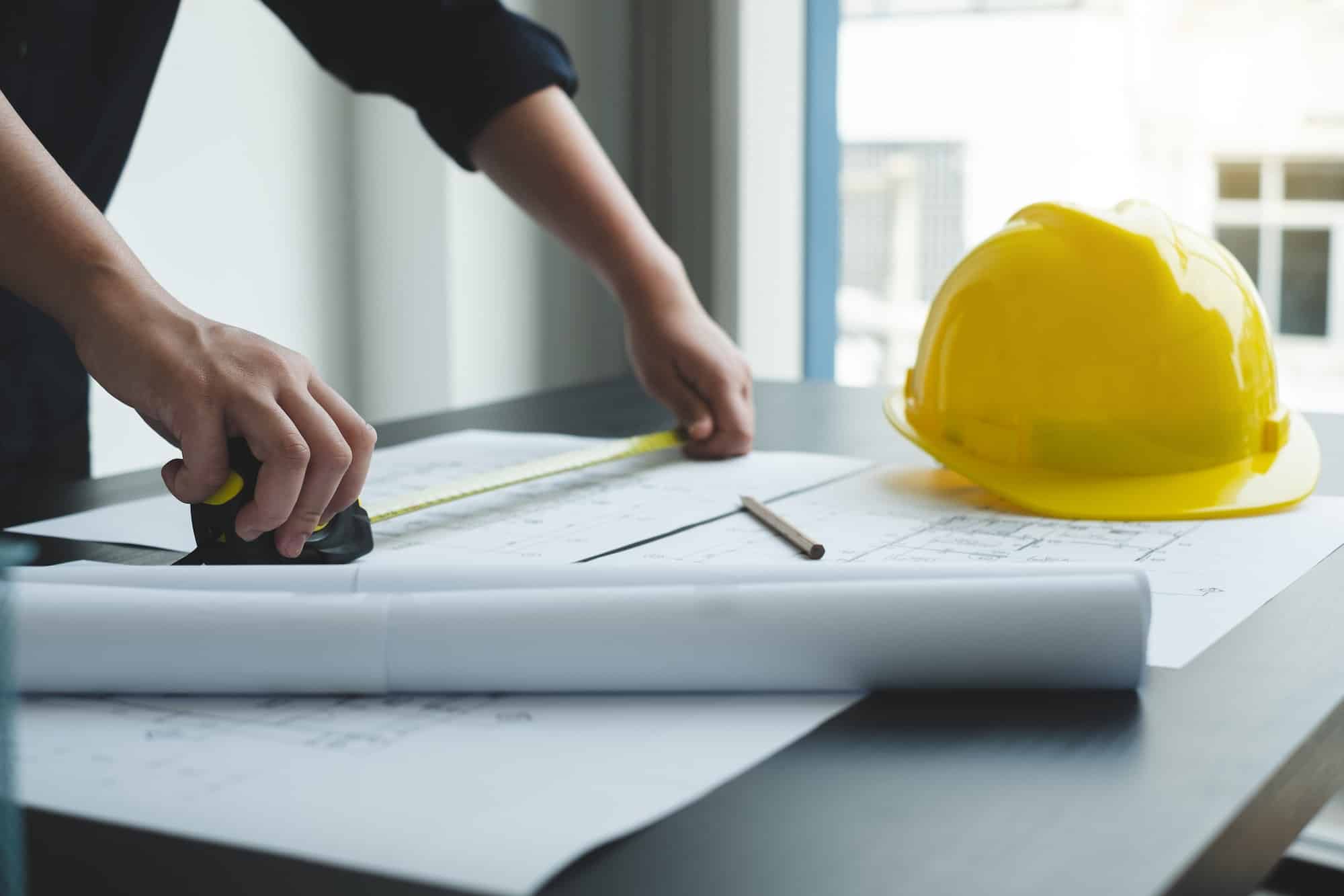 Architects or engineers working construction and drawing construction plans, printing