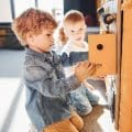 Children have fun in playroom near the wall. Kindergarten educational games