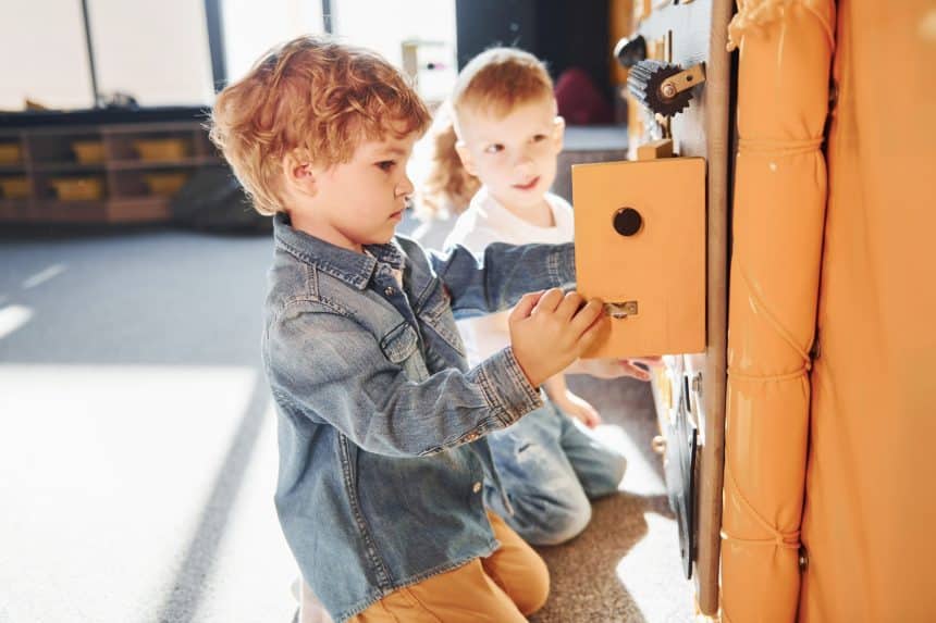 Children have fun in playroom near the wall. Kindergarten educational games