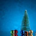 front view small xmas balls mini xmas tree on dark blue background with free space