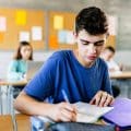 High school young student writing to notebook in class lecture