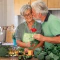 Love concept and Valentine's day. Senior bearded husband offers his wife a red rose.
