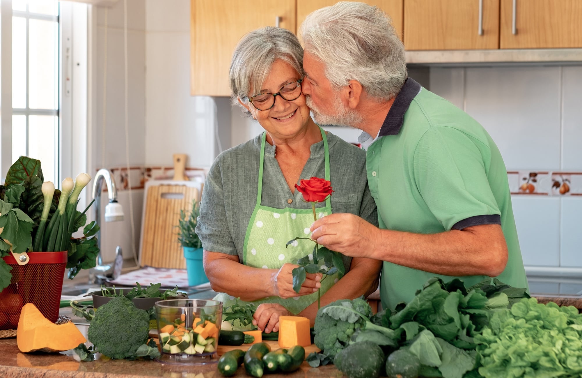 Love concept and Valentine's day. Senior bearded husband offers his wife a red rose.