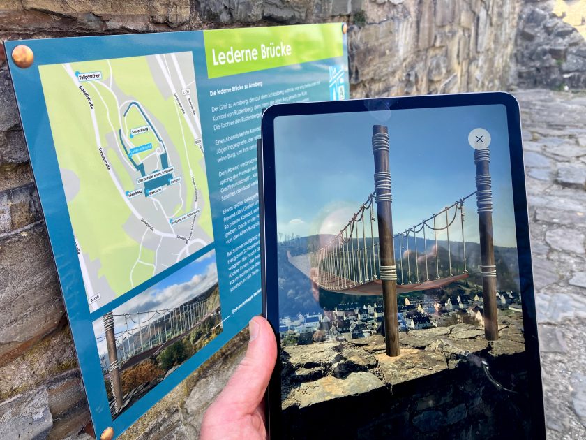 An authentischer Stelle auf dem Arnsberger Schlossberg kann mittels der App die "Lederne Brücke" vom Schloss zur Rüdenburg auf die Bildschirme projeziert werden. (Foto: Stadt Arnsberg)