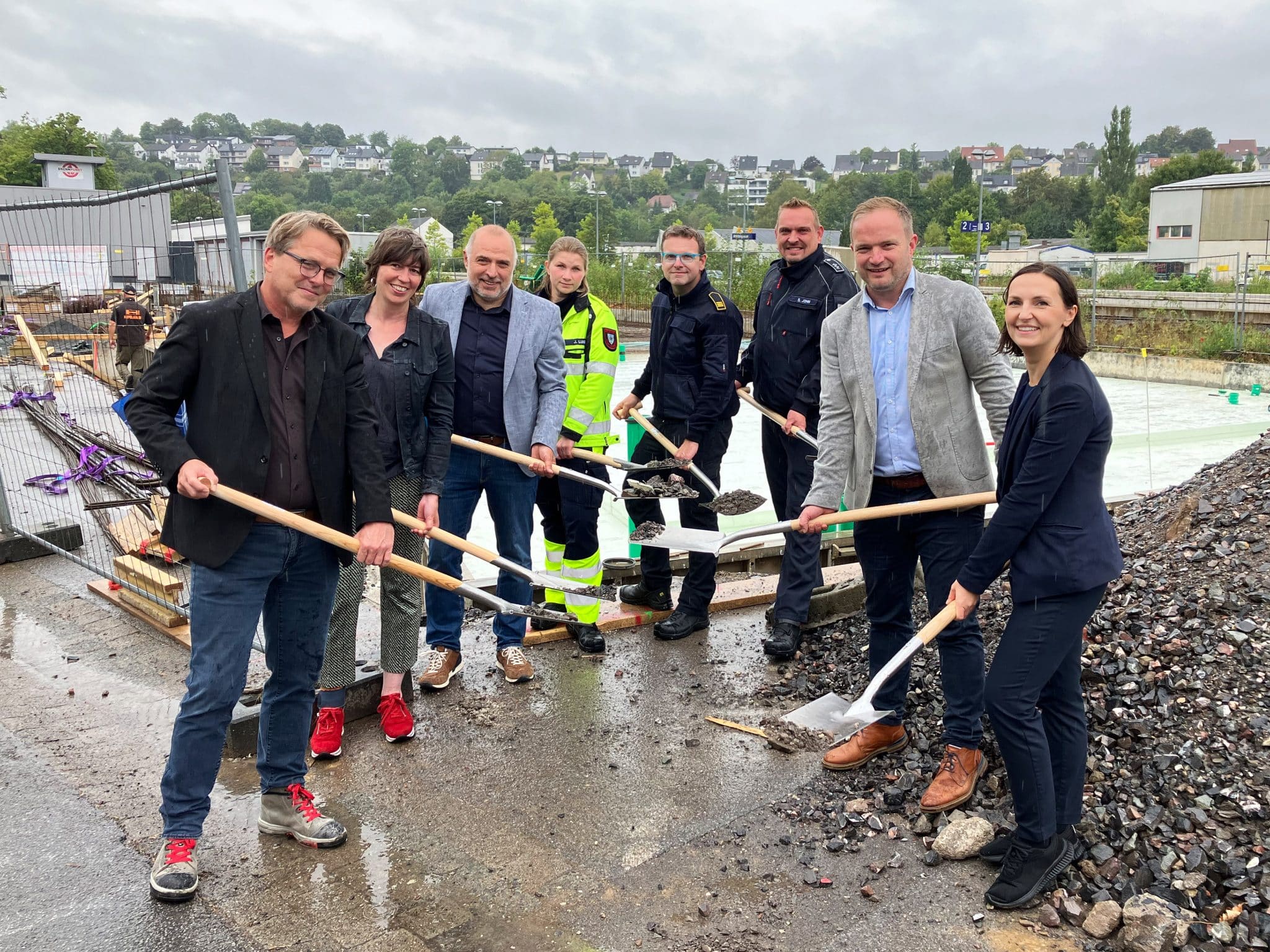 Freude über den Start der Arbeiten für die neue Rettungswache in Arnsberg – trotz des Regens: Christian Weicken, Weicken Architekten, Michaela Röbke, Dezernatsleitung Stadtentwick-lung|Bauen|Umwelt|Mobiliät, Bürgermeister Ralf Paul Bittner, Julia Luig, Rettungsdienst Stadt Arnsberg, Dennis Pingel, Leitung Feuerwehr Stadt Arnsberg, Stephan John, Feuerwehr Stadt Arnsberg, Christopher Hilverling, Erster Beigeordneter der Stadt Arnsberg, sowie Lydia Eichler, Projektleitung Gebäudemanagement Stadt Arnsberg.