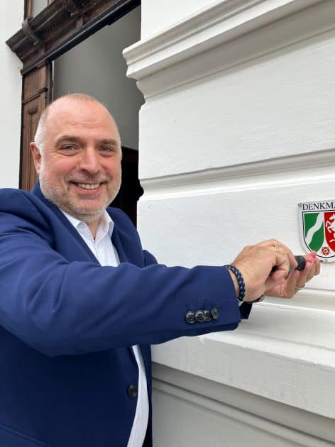 Der Arnsberger Bürgermeister Ralf Paul Bittner hat die neue Denkmalplakette eigenhändig am sanierten Gebäude angebracht. (Copyright: Stadt Arnsberg)