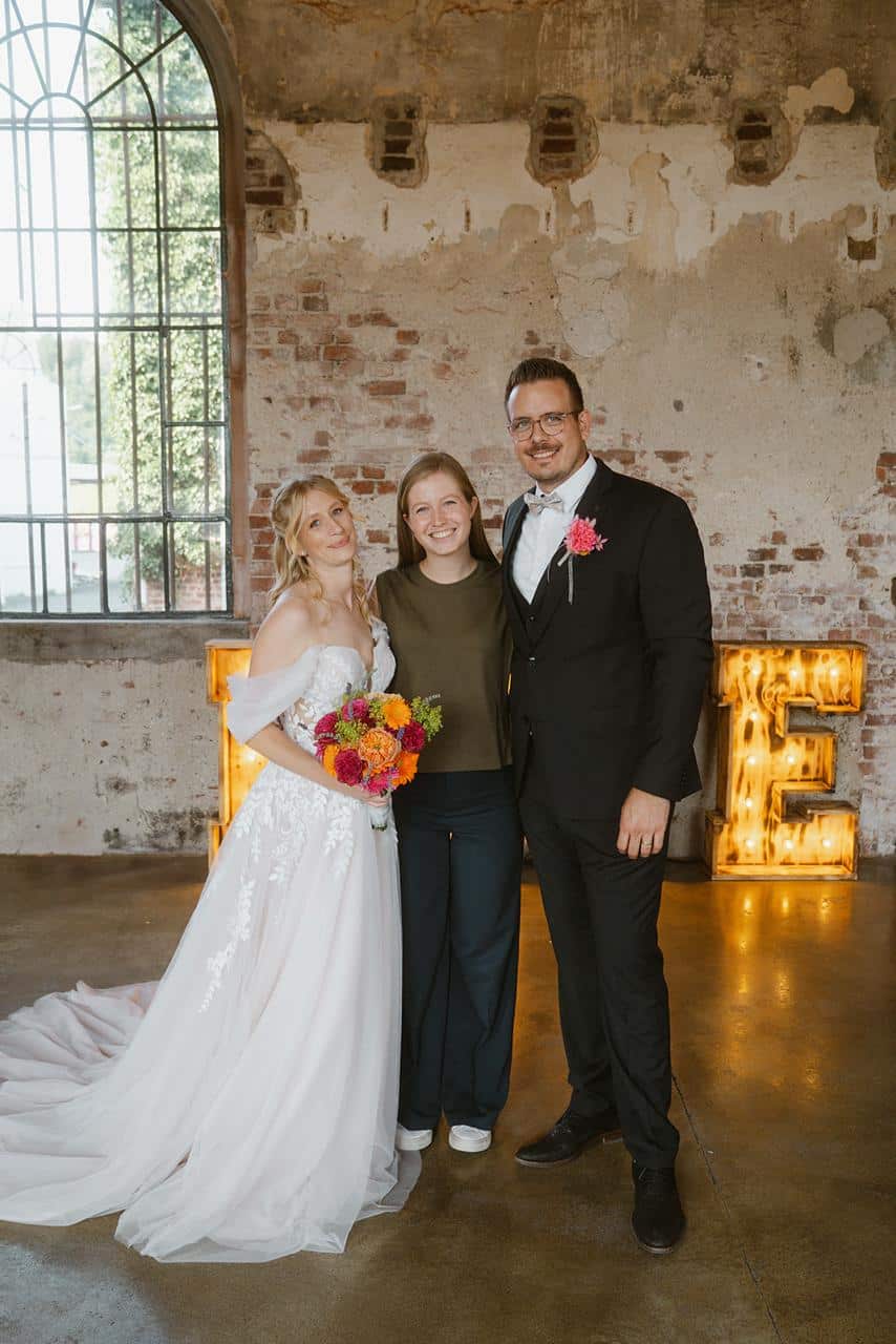 Ein glückliches Paar mit Hochzeitsplanerin Kimberly Hustadt (Foto: Kim Woolf Photography | kimwoolf.com)