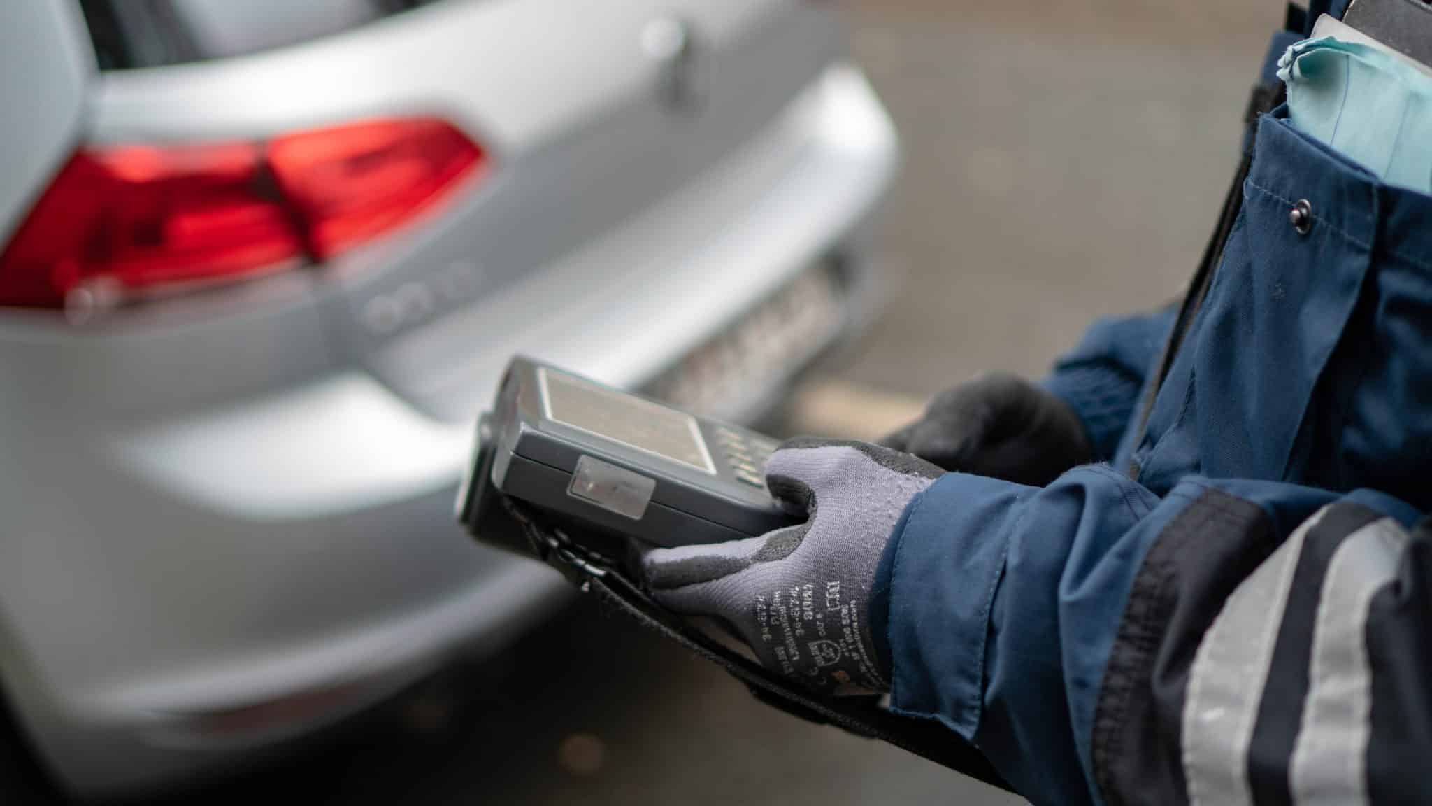 Polizist in Uniform macht Notizen bei einer Verkehrskontrolle (Symbolbild)