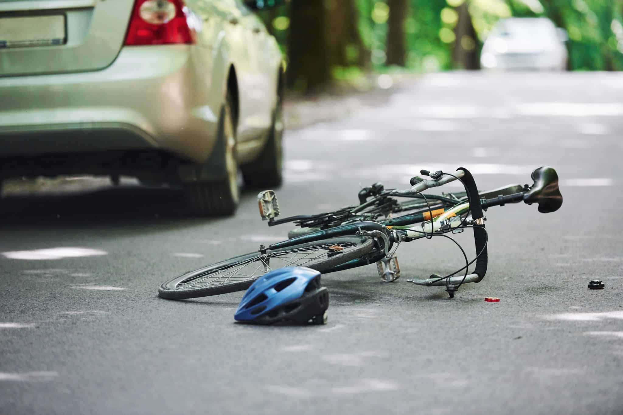 Symbolbild: Fahrrad liegt nach Verkehrsunfall neben Auto auf der Straße