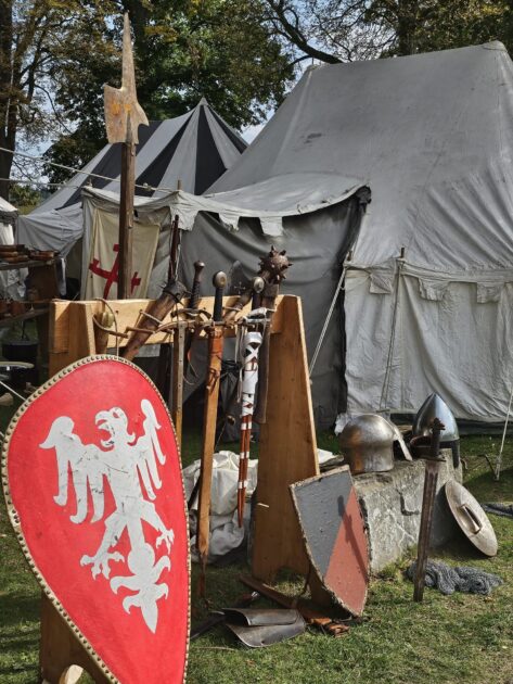 Historisches Lager mit Leinenzelten, Schilden, Helmen und Waffen beim Mittelalter-Herbst