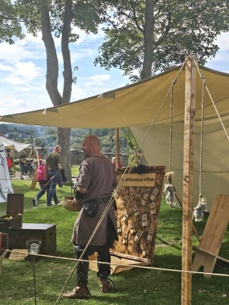 Gewandeter betreut den Stand zum Rattenwerfen auf dem Arnsberger Mittelaltermarkt
